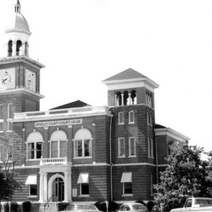 Brick building with clock tower and arched windows and arched entrances