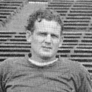 Young white man with bleachers behind him