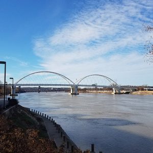 Steel arch bridge over river as seen from shore