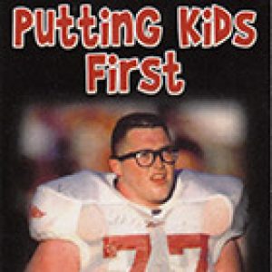 Young white man with glasses in football uniform on "The Brandon Burlsworth Foundation" advertisement