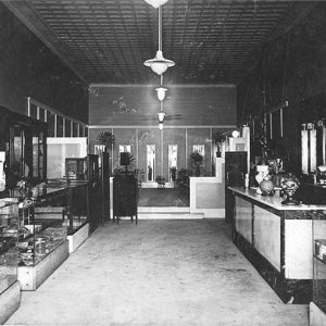 Interior of store with hanging light fixtures and glass display cases across from front desk