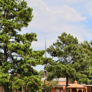 wooden gazebo outside brick chapel with steeple