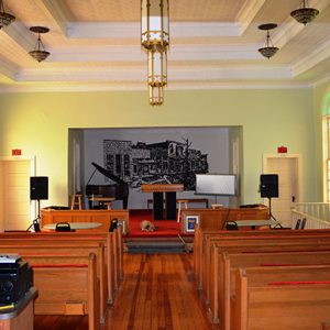 Interior church building with pews and piano on stage