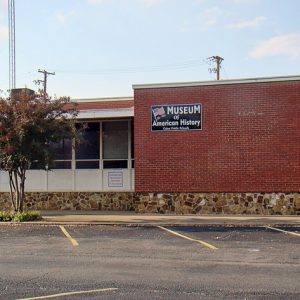 Brick and stone building with sign and parking lot