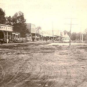 Horse drawn carriage and brick storefronts on dirt roads