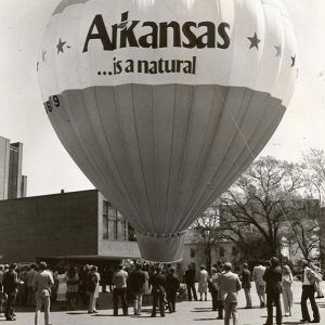 "Arkansas is natural" hot air balloon on street with crowd