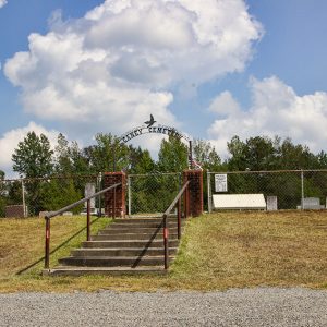 Stairs leading up to "Caney Cemetery" gate with brick columns