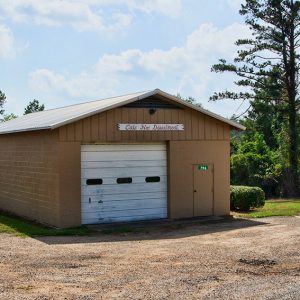 Single-story building with garage door on gravel parking lot