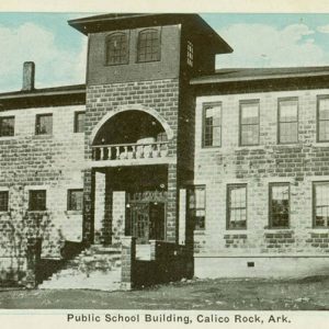 Multistory brick building with covered porch and central tower