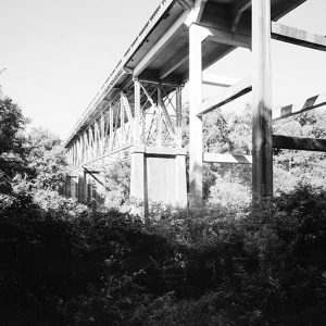 Underside of concrete bridge with steel trusses