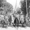 Group of white men in military uniforms on horseback on street