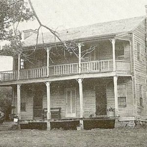 Two-story house with covered porch and balcony and stone chimney