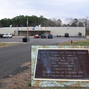 Single-story V. F. W. building with covered entrance on parking lot with plaque in second image