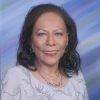 Older African-American woman smiling in silver and white dress