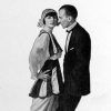 White man in suit dancing with white woman in striped dress