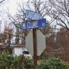 street signs marking the intersection of Catcher and McClure roads in front of house