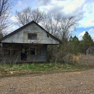 Abandoned building and outbuilding on dirt road