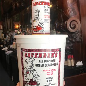 Hand holding up a plastic bucket with spice shaker on top of it in bar