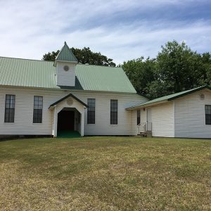 Church building with green roof and cupola above the entrance