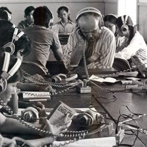 Vietnamese men and women seated at tables listening to instructional material