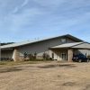 Church building with metal siding and covered entrance with car