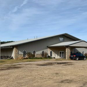 Church building with metal siding and covered entrance with car