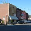 Two-story brick storefronts on street with parked cars