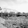 Steel arch truss bridge over nearly dry creek bed