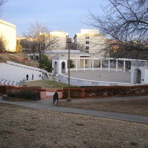 Open air amphitheater on college campus with trees and surrounding buildings