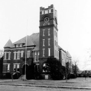 Multistory brick building with clock tower and street