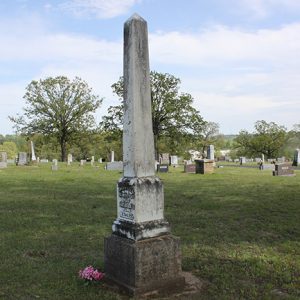 Weathered obelisk shaped monument in cemetery