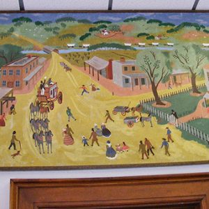 Multicolored street scene painting hanging in hallway