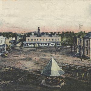 View of town square with gazebo in the foreground and multistory buildings around it