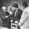 Young white man in suit speaking to group of older white men at a Lion's Club meeting