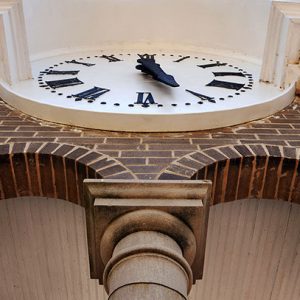 View looking up at clock face on brick clock tower