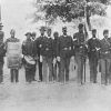 African-American soldiers in blue uniforms with guns drums and flag