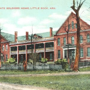 Three-story brick building with balcony and grounds