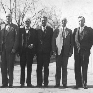 Group of older white men in suits standing together