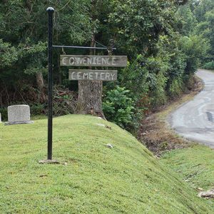 Hanging cemetery sing on slope next to rural road