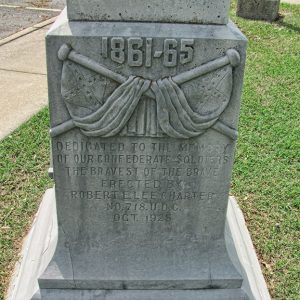 Close-up of crossed flags and text engraved upon the base of obelisk shaped monument