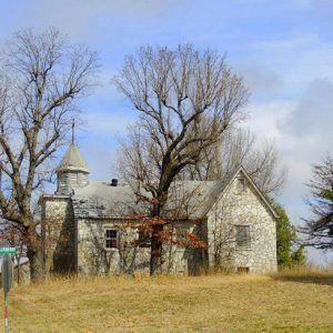 Side view of abandoned church building with cupola on rural road