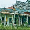 Overgrown and abandoned storefront with covered porch