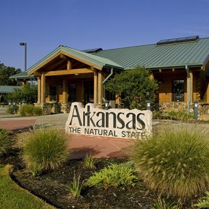 Wood and stone building with "Arkansas the natural state" sign