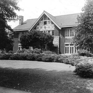 Three-story house with trees and bushes