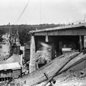 Construction site with two ends of concrete bridge and buildings