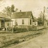 Single and multistory houses with covered porches on dirt road