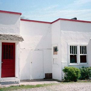 Red and white apartment building on gravel