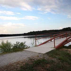 Lake with arched walking bridge and blue skies