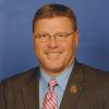 White man with glasses wearing suit and tie