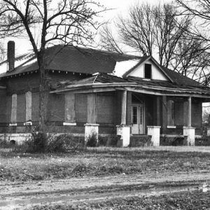 Abandoned brick building with partially collapsed front porch